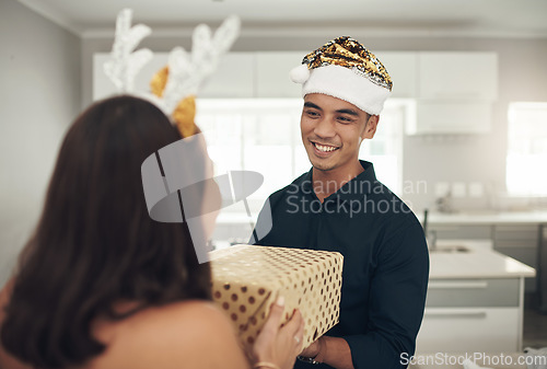 Image of Man, couple and christmas gift for celebration in home with happy partner. Asian guy, festive present and surprise box to celebrate love, care and excited holidays in house, happiness and together