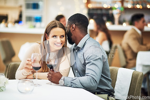 Image of Restaurant date, interracial couple secret and wine celebration of a man at a dinner table. Anniversary happy, valentines day smile and drink at night with love, care and conversation together