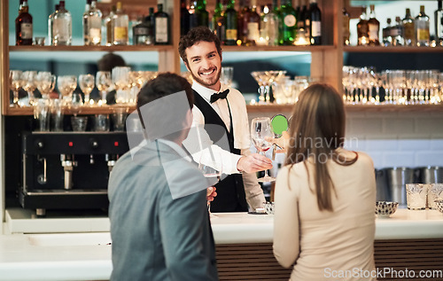 Image of Bar, barman and serve a couple alcohol drinks on a date with hospitality, happy and smile at a hotel. Waiter, bartender and server help customers or people with good service for a celebration