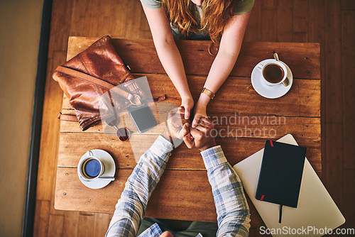 Image of Above, couple and cafe at table with holding hands, love or conversation for romance together. Man, woman and valentines date in coffee shop for support, bonding or talk for happiness, care and trust