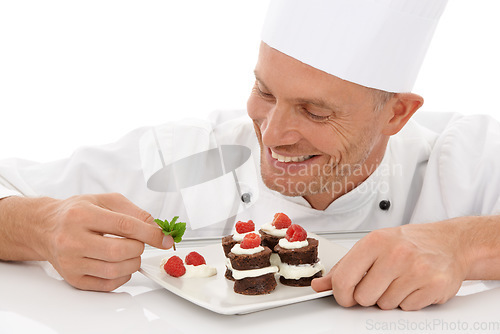 Image of Baking, smile and chef with a dessert for catering isolated on a white background. Cooking, professional and man plating a chocolate cake and fruit on a plate for a food service on a backdrop
