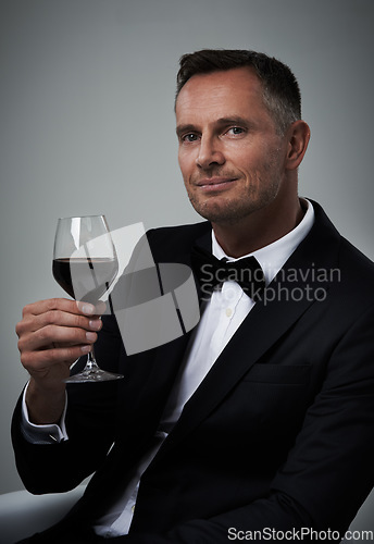 Image of Tuxedo, red wine and man portrait with alcohol in a suit feeling classy with a luxury drink. Gray background, isolated and studio with a model, agent or actor with a glass of rich person with mockup