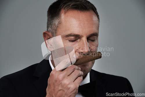 Image of Wealth, vintage and face of man with cigars for smoking habit on gray background for luxury, power and success. Retirement, business gangster and senior male smell tobacco smoke for rich lifestyle