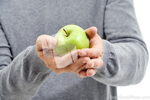 Image of Hand, wellness and male in a studio with a apple for nutrition, diet and a healthy snack with vitamins. Health, natural and healthy man or person with fresh, organic and raw green fruit for a craving