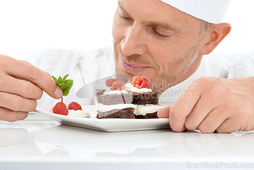 Image of Baking, presentation and chef with cake for dessert isolated on a white background. Cooking, professional and man plating a sweet treat and fruit on a plate for fine dining service at a restaurant