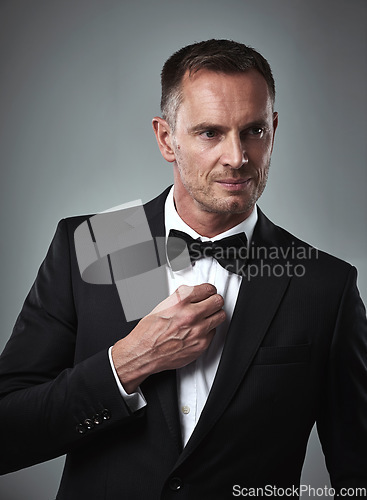 Image of Studio portrait of mature man, tuxedo and handsome, serious and isolated on grey background. Luxury, glamour and wealth, success with celebrity actor style, elegant and date for valentines day.
