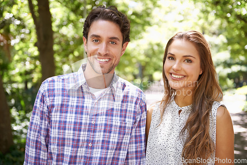 Image of Park, happy portrait and couple in love on a outdoor date with happiness in nature. Sunshine, vacation and young fun with a smile in summer on holiday feeling relax in sun with blurred background