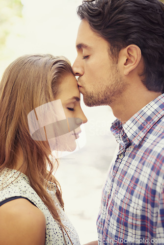 Image of Kiss, affection and couple with love in nature on a date, bonding and loving in a relationship. Content, romance and man kissing a woman on the forehead during valentines day at a park in Italy