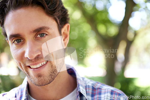 Image of Happy, portrait and man at a park for travel, relax or day off, cheerful and smile on nature background. Face, real and normal guy enjoying the weekend in a forest, content and satisfied in nature