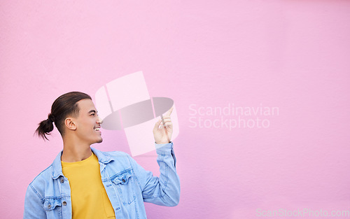 Image of Happy, smile and man pointing in a studio with mockup space for advertising, marketing or product placement. Happiness, excited and male model showing mock up or copyspace isolated by pink background