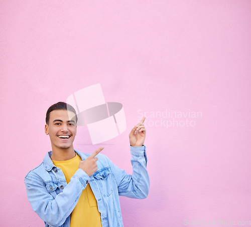 Image of Man pointing, wall mockup space and smile for portrait with fashion, happy and excited face by backdrop. Gen z model, gesture and hands with happiness, mock up and student by urban pink background