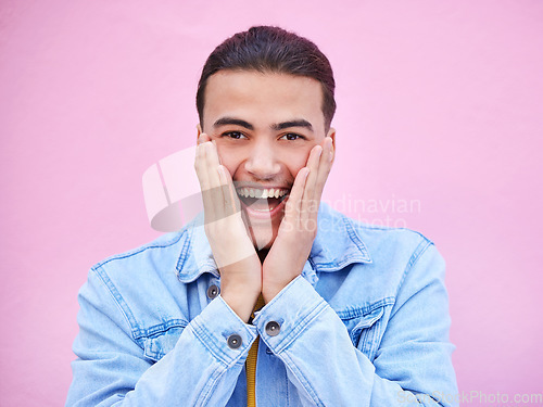 Image of Man, hands and cheeks for surprise in portrait with happiness, excited and pink wall background. Happy gen z model, wow face and smile for announcement, fashion and news for career, success and goal
