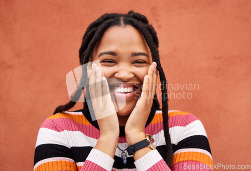 Image of Excited black woman, hands and cheeks in portrait by city wall background with smile, happiness and beauty. Gen z student girl, young model and fashion in urban metro for adventure, happy and freedom