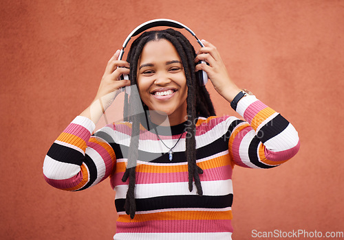 Image of Wall, portrait and black woman with headphones, smile and carefree with music, streaming and joyful. Face, Jamaican and female with headset for audio, sounds and chilling with happiness and relax