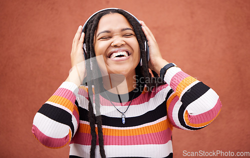 Image of Black woman, music headphones and happy by wall in city for walk, adventure and me time with smile. Young gen z girl, audio streaming and excited listening on radio, website and happiness in metro