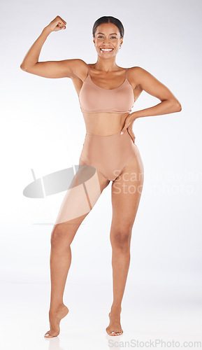 Image of Health, body and portrait of a woman in a studio for healthy weightloss, strength or wellness. Happy, smile and slim female model showing or flexing her arm muscles posing isolated by gray background
