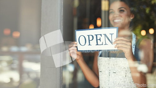 Image of Small business, open sign and woman in cafe window for welcome, advertising and coffee shop promotion. Manager startup owner and excited and happy entrepreneur with opening poster for restaurant