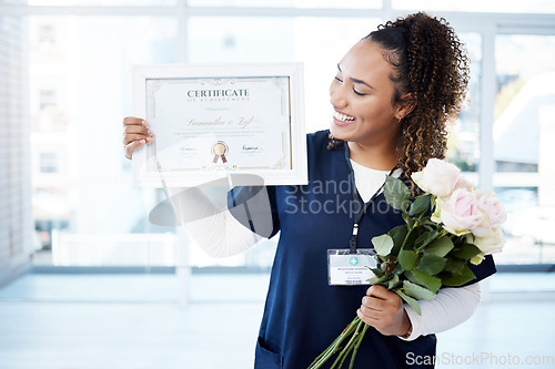 Image of Certificate, flowers and a black woman graduate in the hospital feeling proud of her achievement. Smile, graduation and qualification with a happy young female nurse standing alone in a clinic