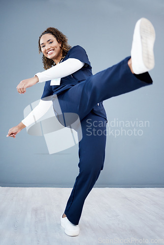 Image of Kick, healthcare and black woman with celebration, achievement and grey studio background. Portrait, Jamaican female and medical professional with leg in air for happiness, promotion and employee