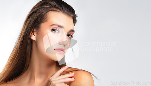 Image of Portrait, beauty and mockup with a model woman in studio on a gray background for natural skincare. Face, mock up and cosmetics with an attractive young female posing to promote a product on ad space