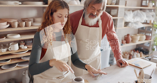 Image of Art teacher, pottery and senior man in a class, learning tips in art class. Young woman teaching old man to roll clay, sculpture and giving instruction in studio to learn new skill in retirement