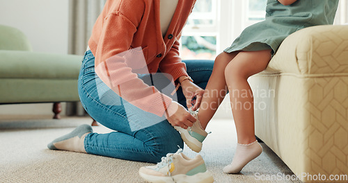 Image of Mother, child and shoes in preparation for school, learning or education in the bedroom at home. Mom helping little girl with shoe getting ready for academy, college or elementary at the house