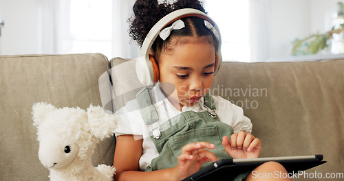 Image of Tablet game, headphones and relax child gaming, having fun or play online games on mobile device or digital tech app. Kid entertainment, youth lifestyle and young gamer girl playing on ui touchscreen