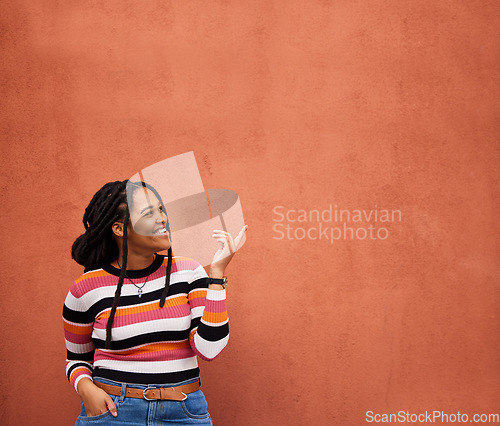 Image of Mockup, pointing or black woman with marketing, product placement or branding space on wall background. Smile or African gen z girl advertising discount deal, sales offer or promotion announcement