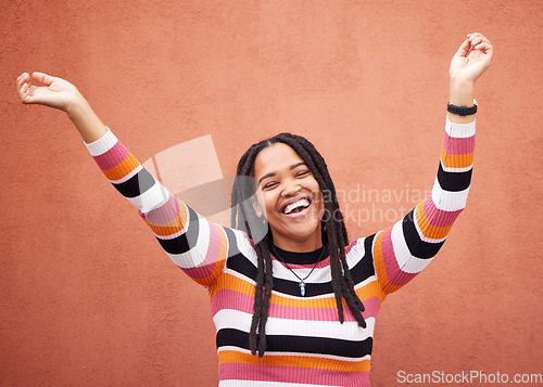 Image of Celebration, energy and woman by a wall in the city on a walk while on a holiday or weekend trip. Happiness, smile and African female celebrating with freedom in urban town on a vacation or adventure