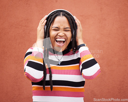 Image of Loud music, headphones and black woman isolated on orange wall singing, wow and excited for gen z subscription. African person or happy youth listening to 5g audio technology or streaming services