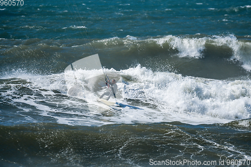 Image of Kitesurfer riding ocean waves