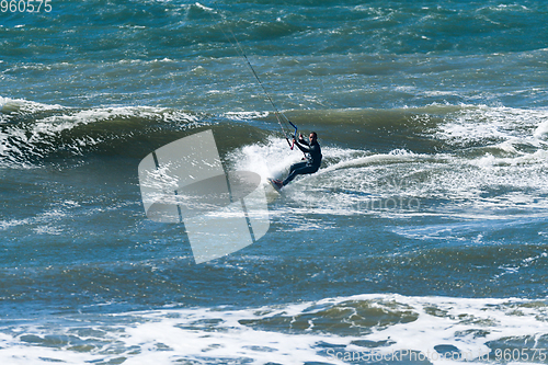 Image of Kitesurfer riding ocean waves