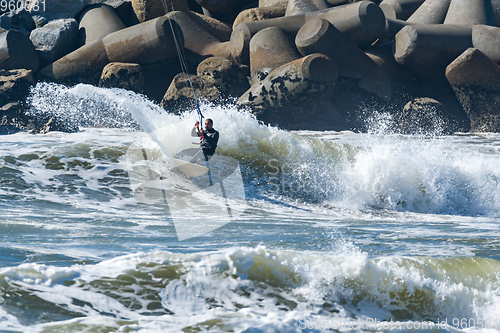 Image of Kitesurfer riding ocean waves