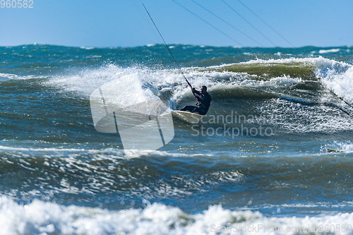 Image of Kitesurfer riding ocean waves