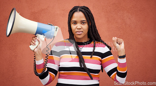 Image of Protest, megaphone and portrait of a woman by a wall in the city for freedom, equality and human rights. Fist, speaker and African female fighting at a rally for justice, democracy and racism in town