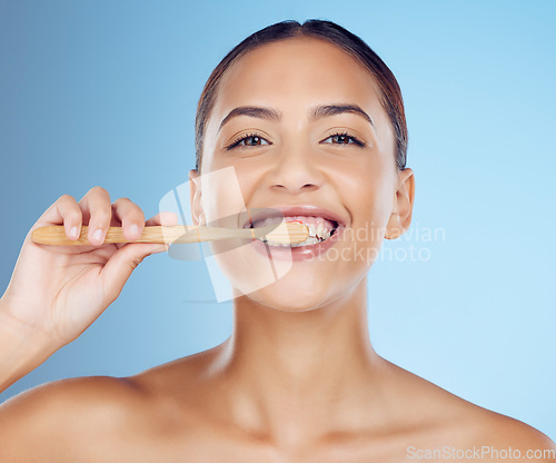 Image of Teeth, woman and portrait of bamboo toothbrush for dental wellness, healthy cleaning or beauty cosmetics. Happy female, eco wooden brush and toothpaste of mouth, face smile and studio blue background