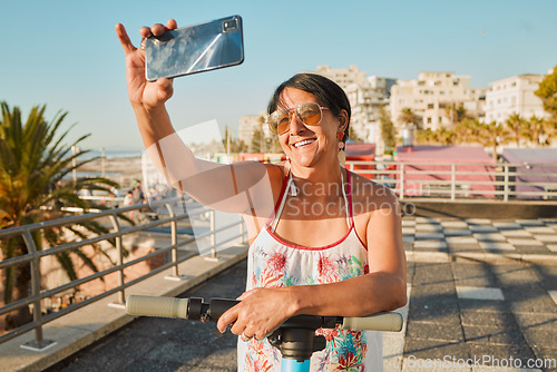 Image of Vacation, selfie and happy senior woman in retirement riding a scooter on the beach promenade. Happiness, smile and elderly female taking picture while having fun on holiday or weekend trip in Mexico