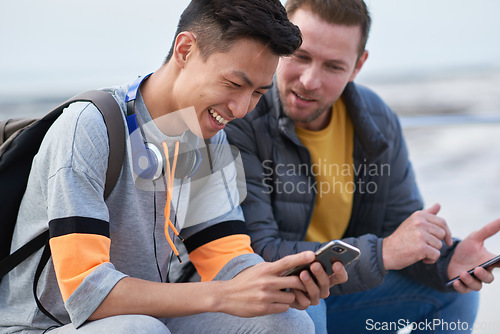 Image of Asian man, phone and friends by the sea happy about mobile connection and travel. Technology, social media scroll and ocean with men streaming a video with 5g network outdoor with happiness together