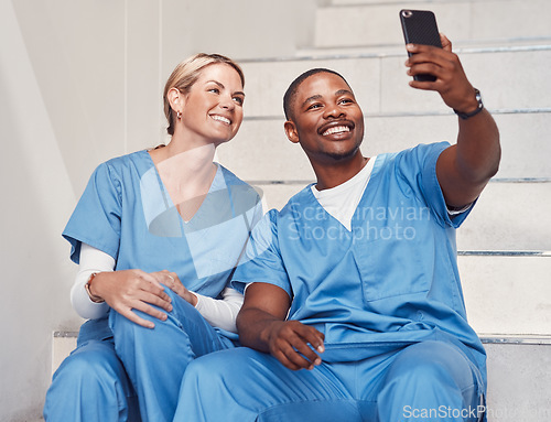 Image of Healthcare, doctors and selfie in hospital, smile and fun together, bonding or achievement. Medical professionals, woman or black man with smartphone, picture for memories or in clinic with happiness