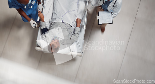 Image of Hospital bed, icu healthcare and doctor with patient in a medical clinic from above. Emergency, wellness team and man going into surgery for injury, health care check or wellness consultation