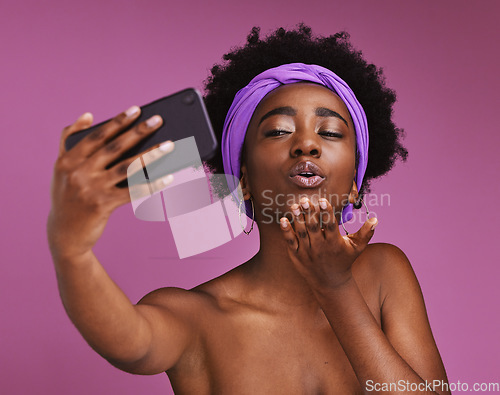 Image of Selfie, love and black woman blowing a kiss isolated on a purple background in studio. Care, beauty and African girl with a photo, video call or communication on a mobile while showing affection