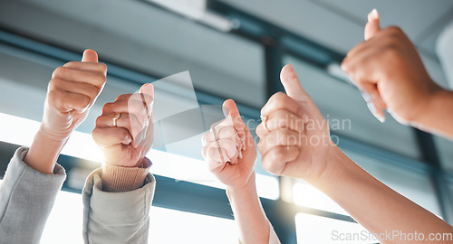 Image of Hands, thumbs up and collaboration with a business team in celebration together at the office from below. Winner, teamwork or gesture with a man and woman employee group celebrating at work closeup