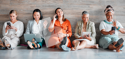 Image of Teamwork, technology and diversity with a business team sitting on the floor in their office for work. Collaboration, communication and corporate design with a woman employee group working together