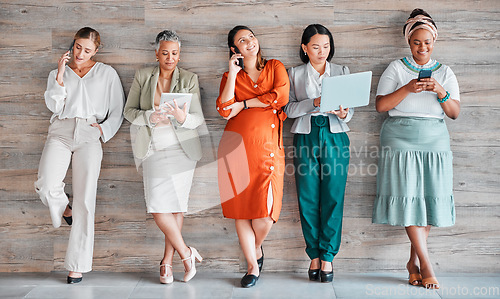 Image of Wall, business and women with devices, online reading and connection for social media, typing and communication. Diversity, female employees and happy coworkers chatting, texting and search internet