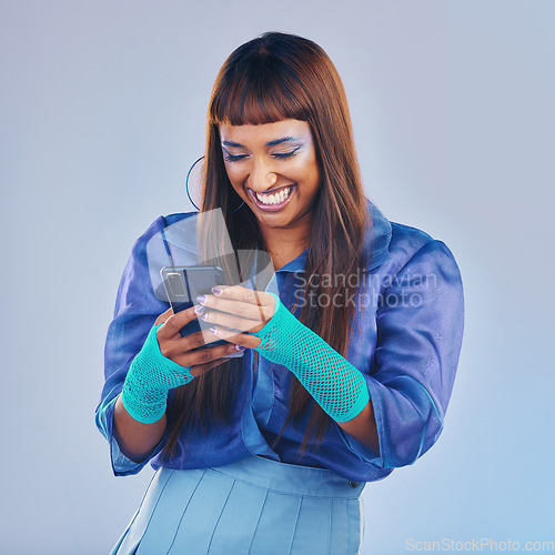 Image of Woman, phone and laughing for funny joke, meme or social media isolated against a studio background. Happy female model smiling and laugh in fashion on mobile smartphone for networking with fun humor