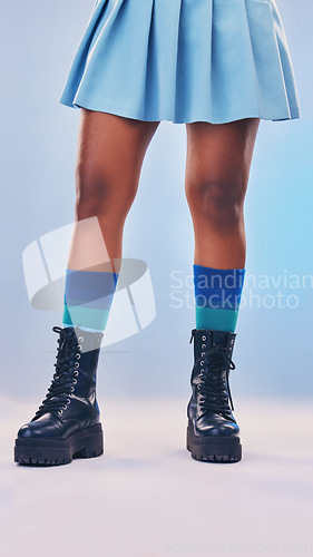 Image of Boots, gen z fashion and legs of a young women in a studio with rock and pastel punk aesthetic. Isolated, blue background and colorful clothes of a person with creative cyberpunk and unique clothing