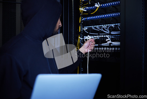 Image of Thief, programming and hacker stealing software, website data and information on server on a laptop. Connection, criminal and man hacking into a network for hardware, coding and cyber crime at night