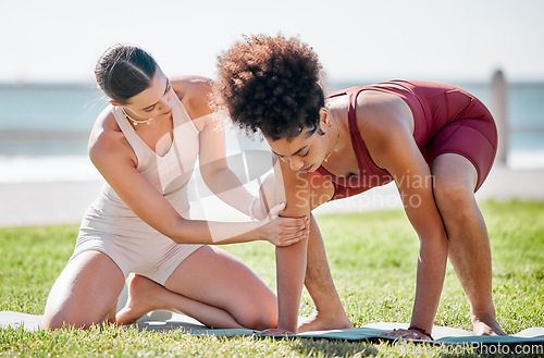 Image of Yoga, personal trainer or women support, helping and learning balance, training and exercise on beach or park. Mentor with black woman or client in pilates workout on grass sports for body wellness