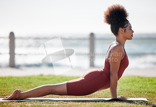 Image of Yoga, fitness and black woman stretching on grass for healthy lifestyle, body wellness and cardio workout. Sports, pilates training and girl doing meditation, cobra stretch and exercise for peace