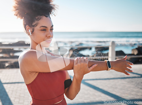 Image of Stretching, fitness and woman with music for running, exercise and cardio in California. Ready, warm up and runner girl thinking of a workout start with audio for motivation while training by the sea